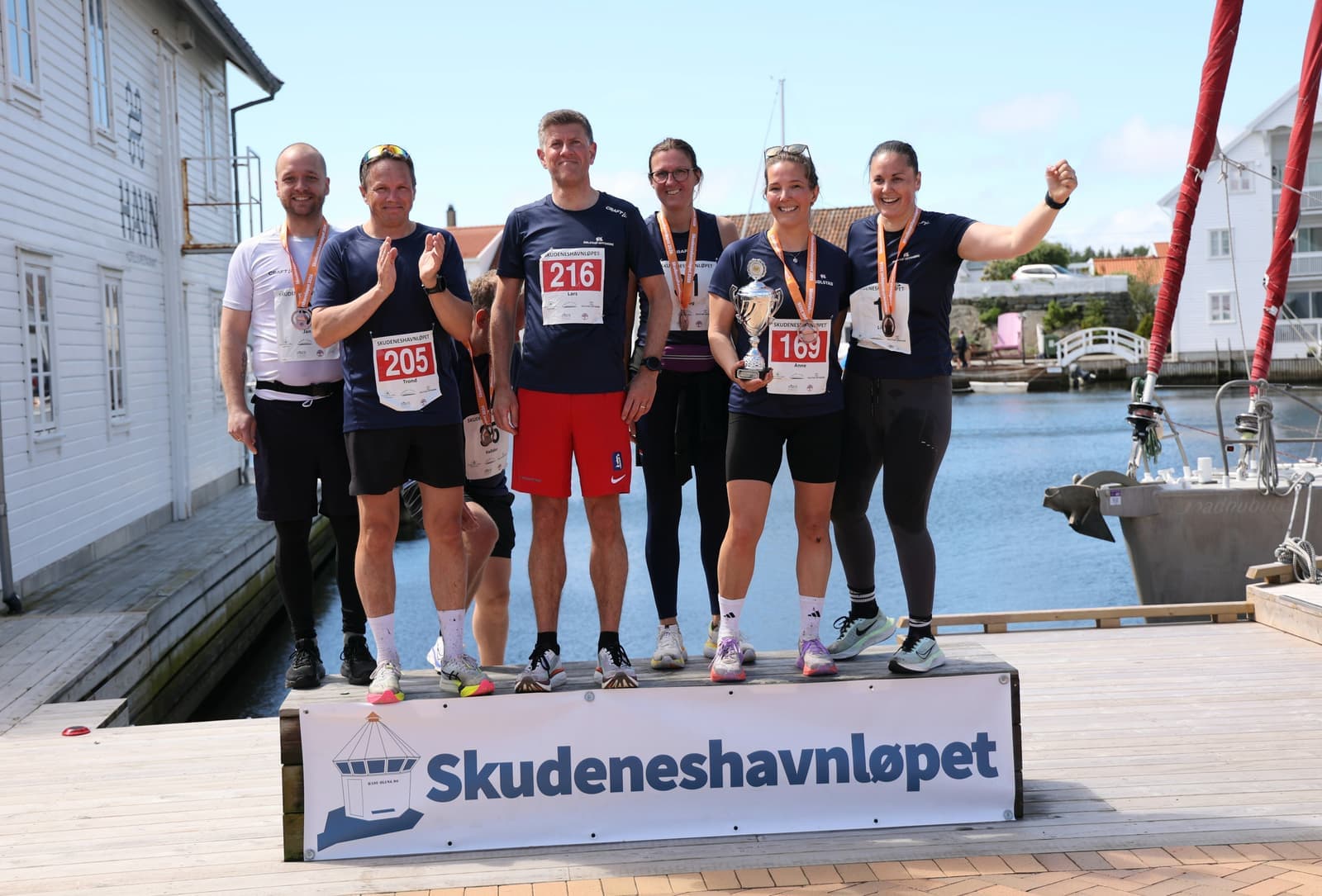 Solstad Running Team på premiepallen med vandrepokalen ved havnen i Skudeneshavn